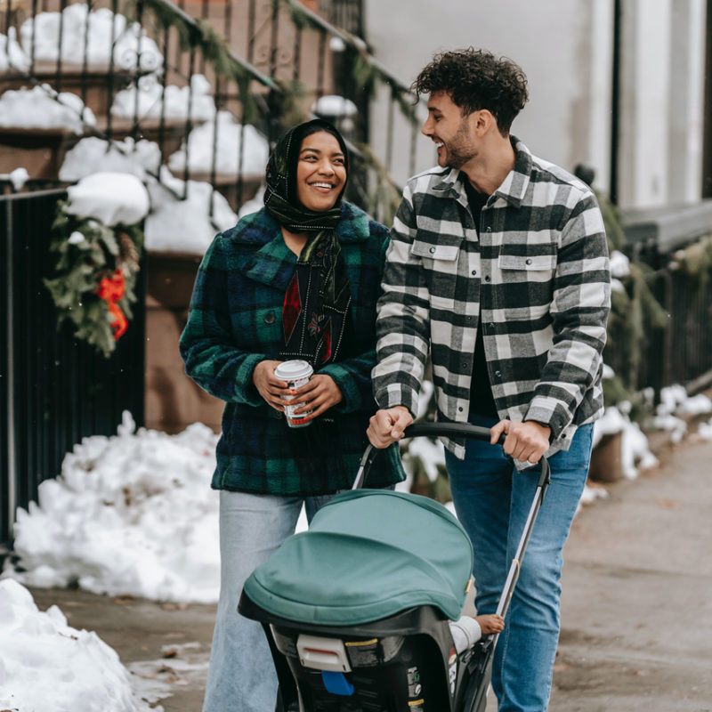 couple pushing a baby in a stroller in a city