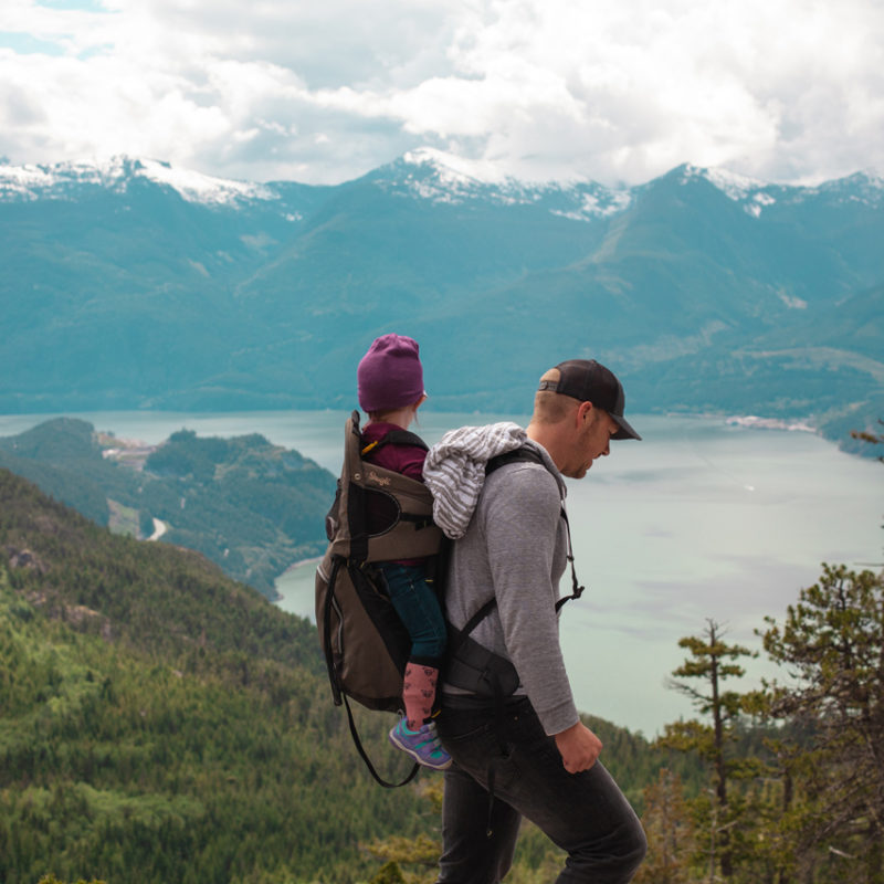 dad hiking with small child on back